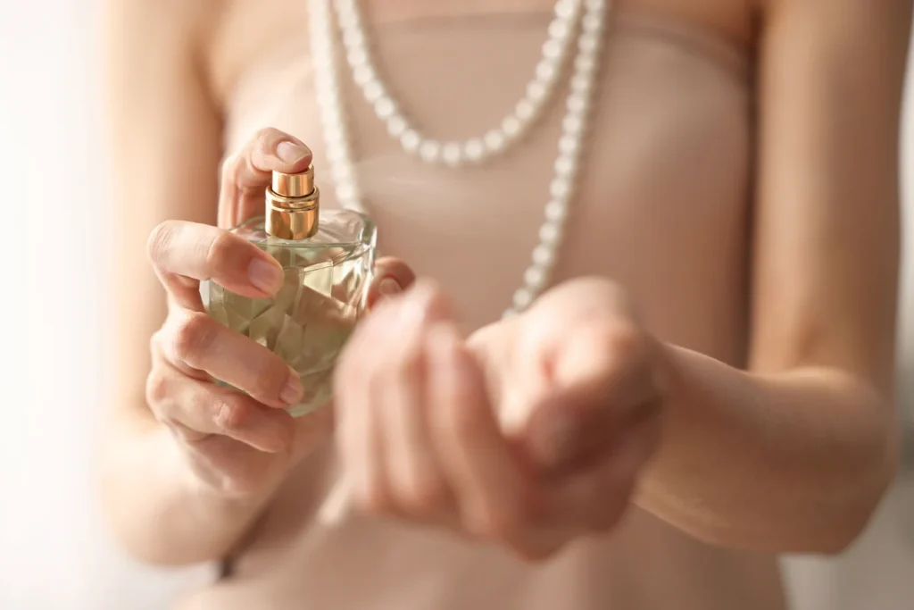 Žena nanáša parfum na zápästie